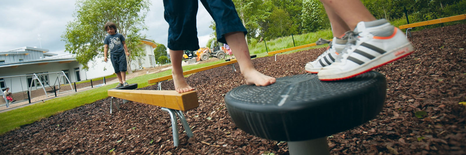 A low angle view of an obstacle course as children make their way round it.